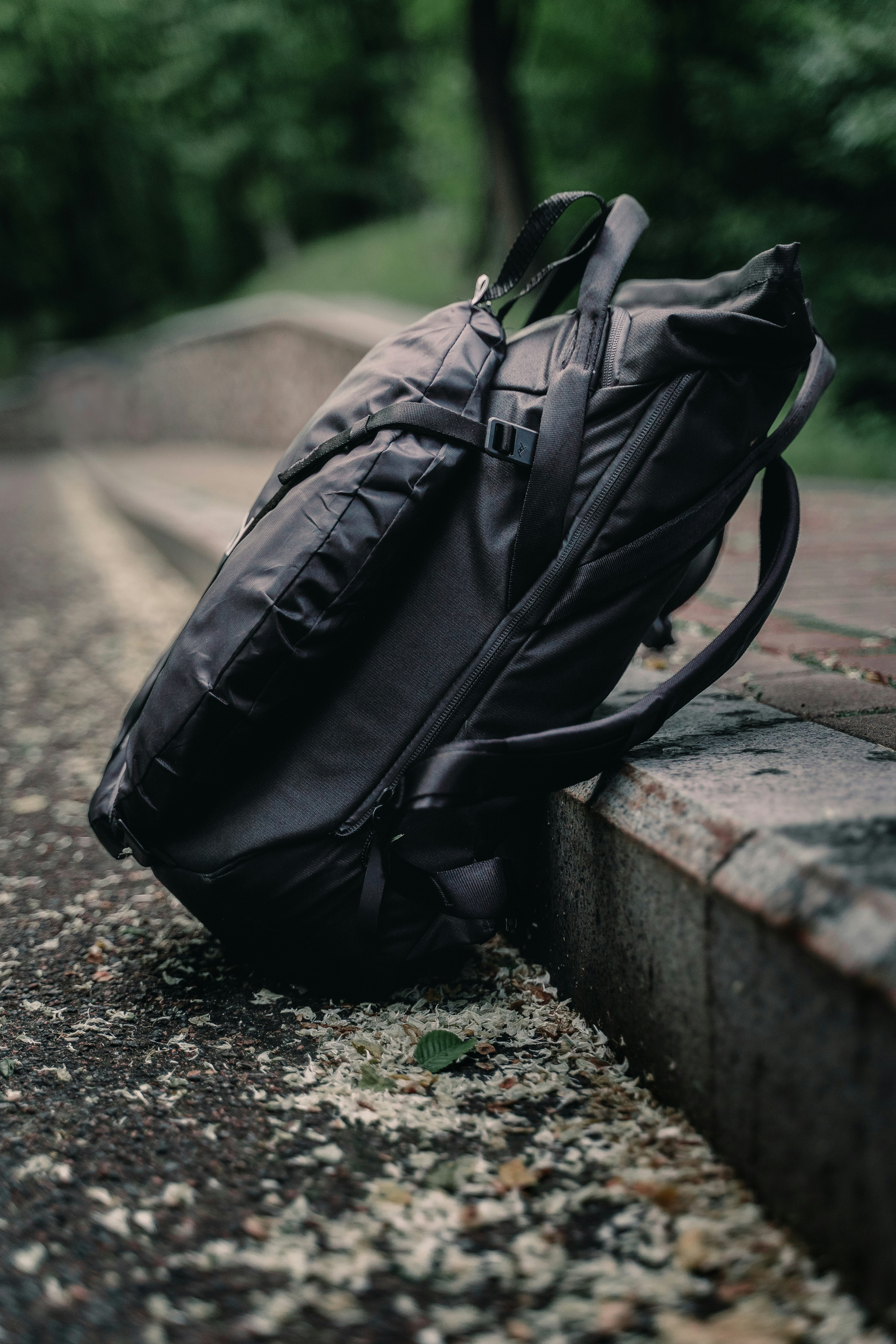 black leather backpack on gray concrete bench